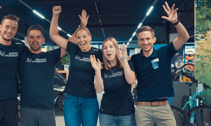 Constanze Kanzlsperger, Lisa Motoc, Thomas Achatz und zwei weitere Mitarbeiter stehen nebeneinander lächeln jubelnd in die Kamera.