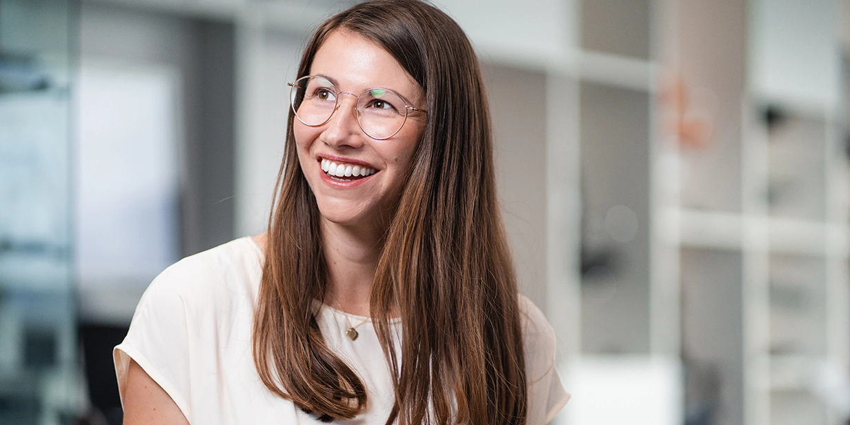 Svenja Winter trägt ein weißes T-Shirt und schaut zufrieden zur Seite.