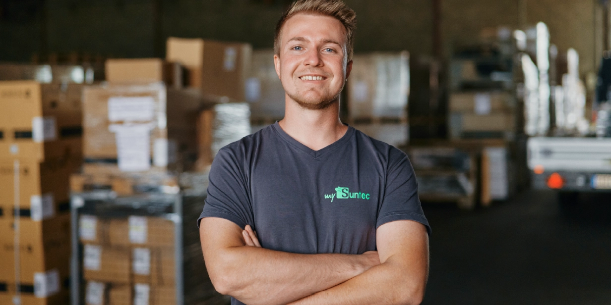 Marvin Zaremba steht mit verschränkten Armen und lächelt in die Kamera.