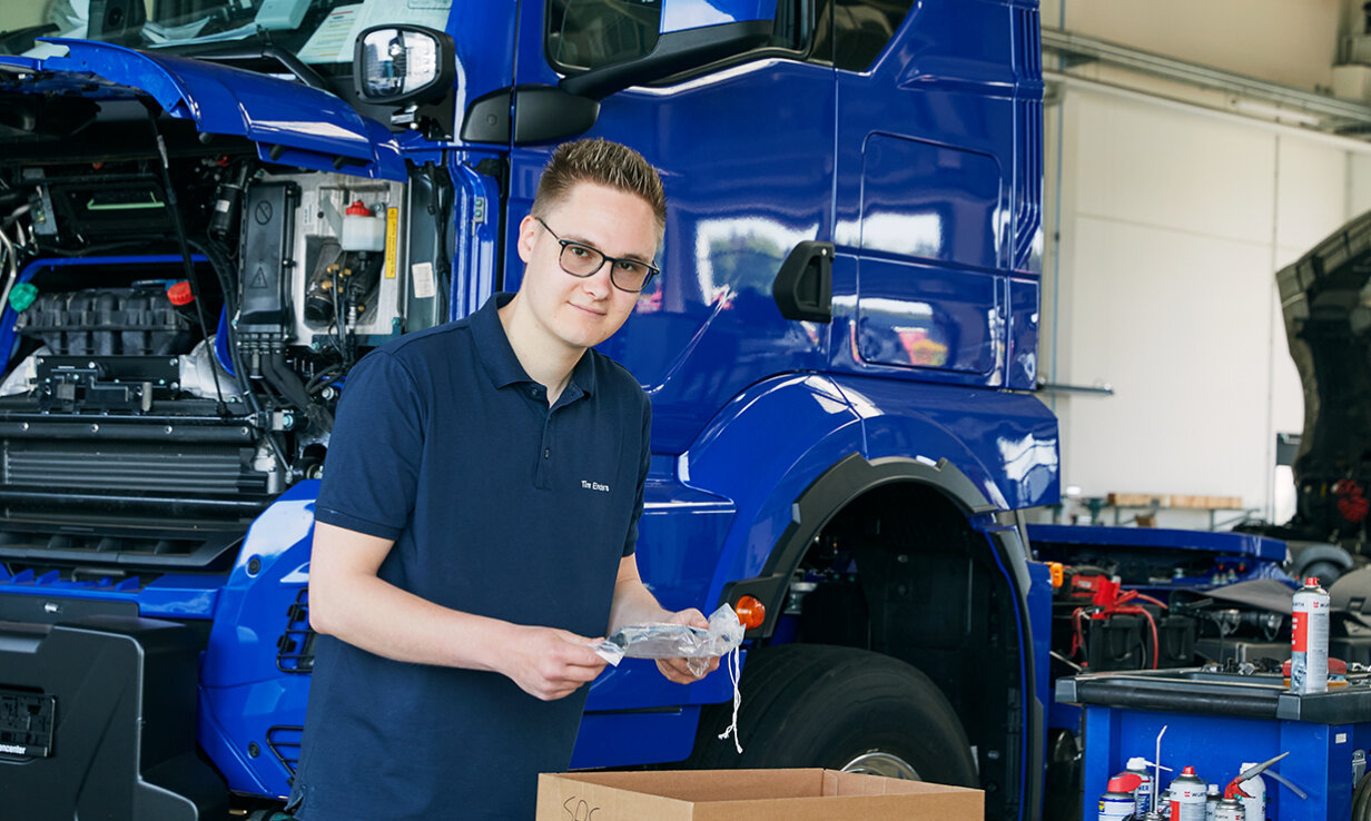 Tim Enders steht vor einem blauen Lastwagen.