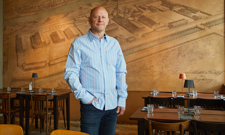 Sven Olufs steht in einem leeren Restaurant.