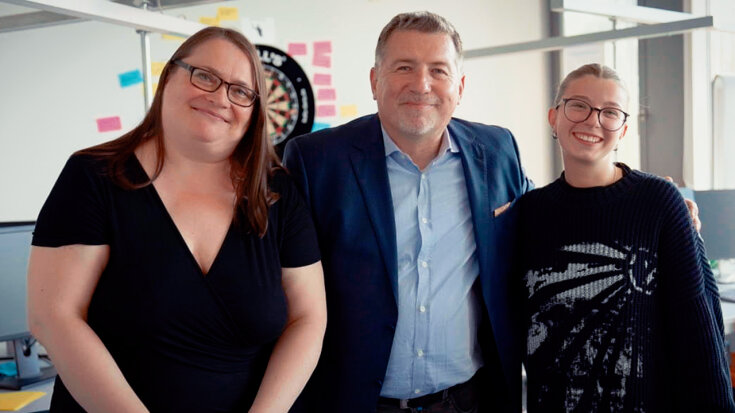 Peter Kincer, Elzbieta Karczewska und eine junge Praktikantin lächeln Arm in Arm in die Kamera.