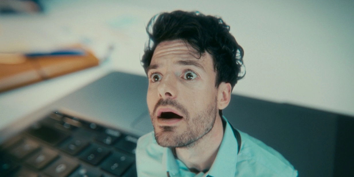 Mann mit geweiteten Augen, offenem Mund und angespannter Stirn