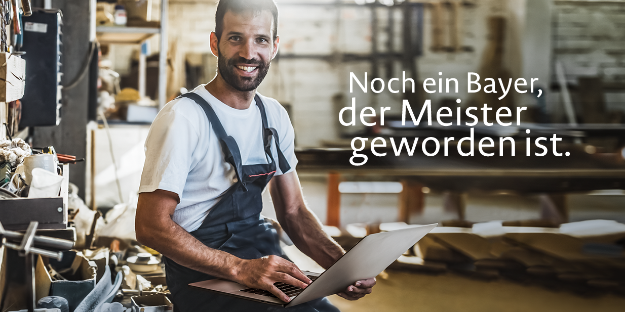 Ein Mann mit blauer Latzhose sitzt lächelnd in einer Werkstatt und hält ein Laptop in der Hand. Die Bildaufschrift lautet: "Noch ein Bayer, der Meister geworden ist."